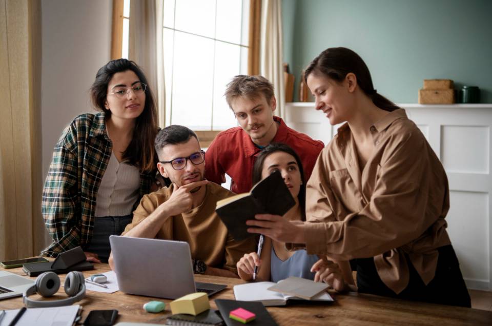 Colleagues reading from a book during study session